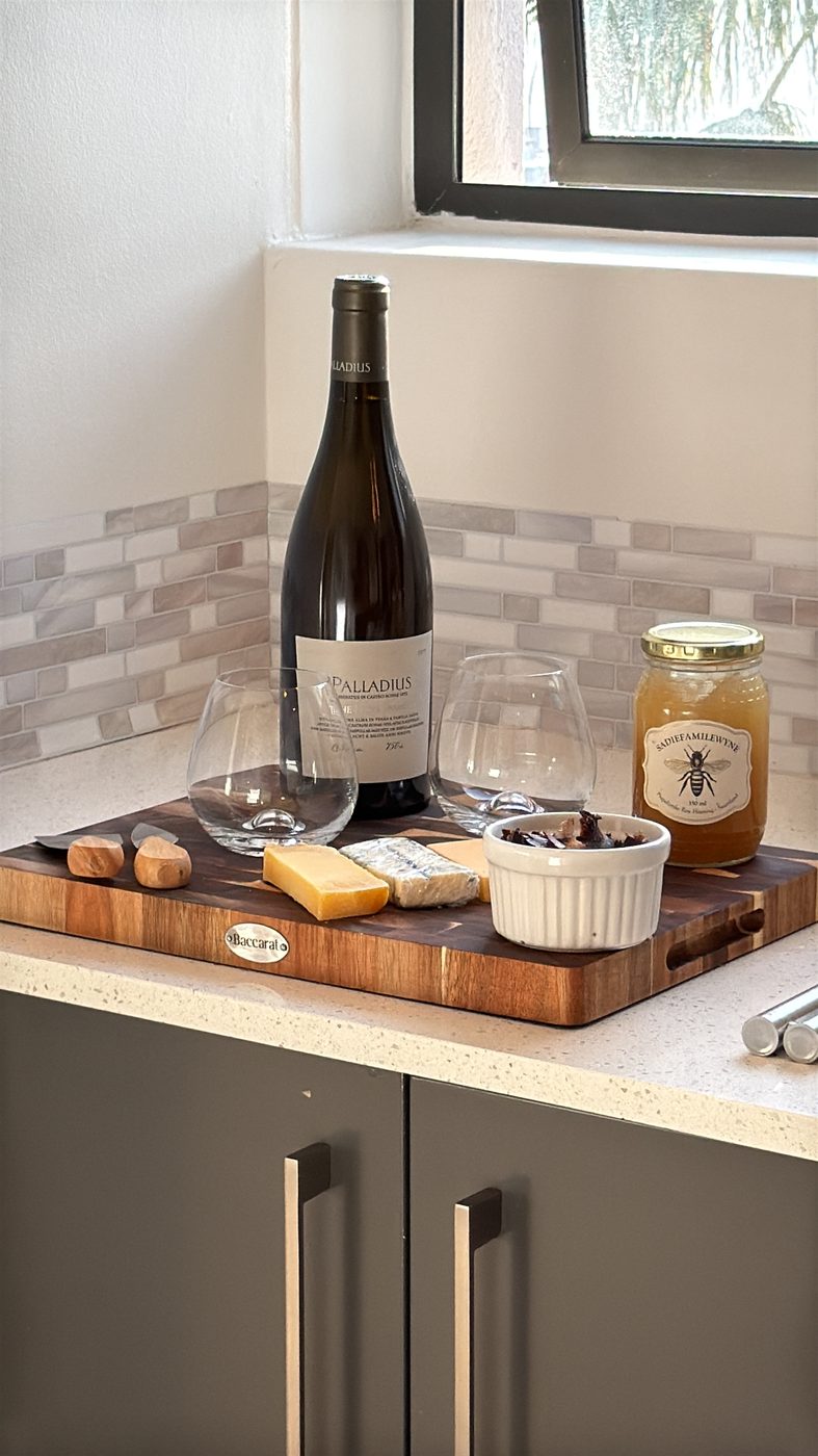 Wine, cheese and honey on a wooden board beside two glasses