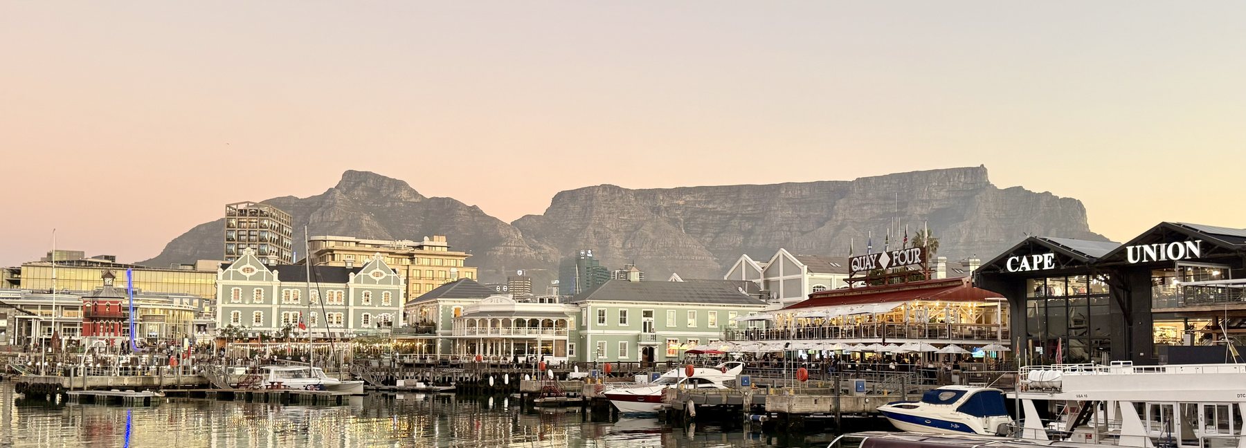 The V&A Waterfront harbour at dusk with Table Mountain behind